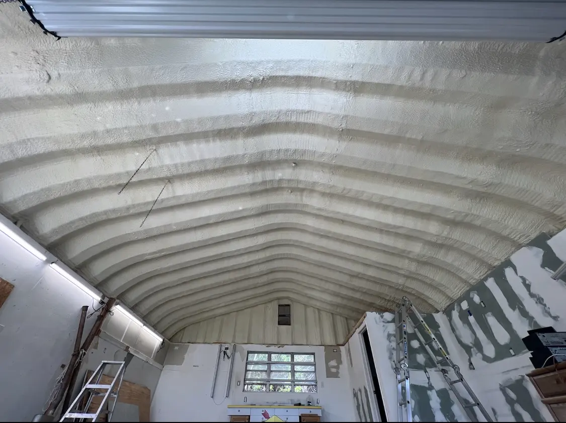 Spray polyurethane foam applied to the underside of a metal roof deck in Bryan